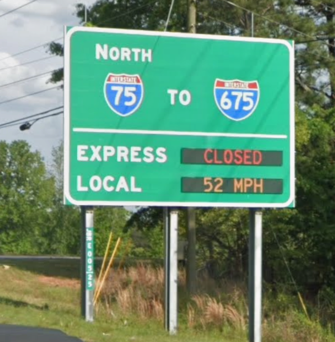An overhead electronic sign displays "EXPRESS LANE CLOSED" at the interchange for I-75 North and I-675.